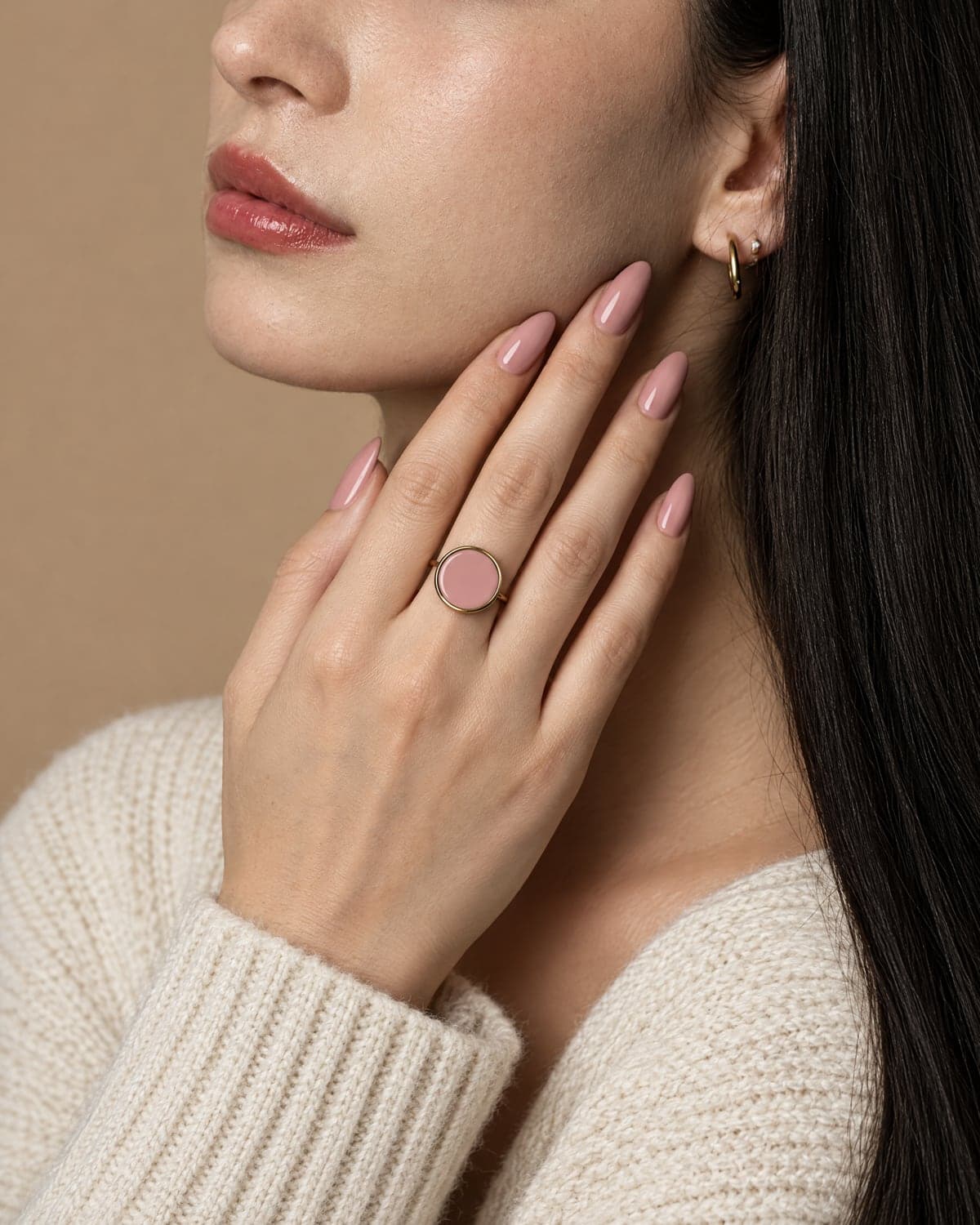 Cliente au vernis nude portant la bague or à pastille nude assortie