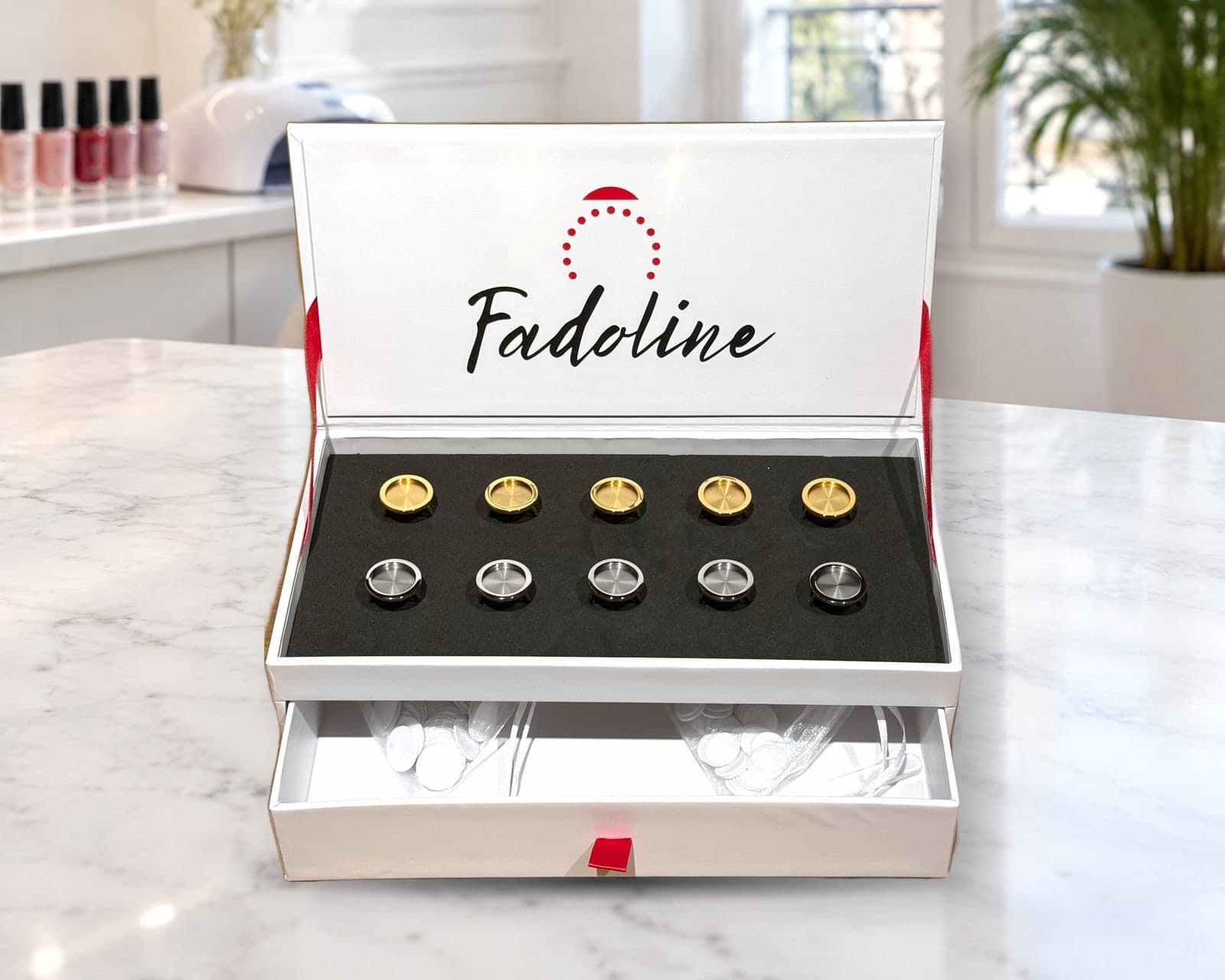 Coffret Fadoline MIX ouvert sur une table de manucure en institut : 5 bagues or, 5 bagues argent et tiroir à accessoires